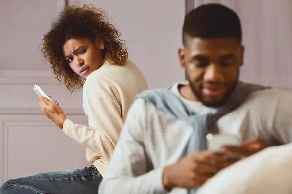 stock image Jealousy. Woman suspecting husband cheating on her, texting on phone