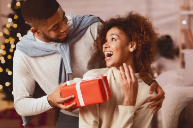 Ne güzel bir sürpriz. Adam kız arkadaşına Noel sürprizi yapıyor, rahat bir odada oturuyor.