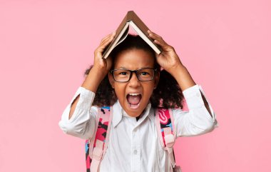 Karantina 'nın sarı arka planının başında dikilmekten yorulmuş kızgın liseli kız kitap tutuyor. Stüdyo Çekimi