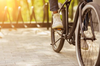 Klasik ayakkabılı işadamının klasik bisiklet sürerken çekilmiş fotoğrafı, pedalların üzerinde ayaklar.