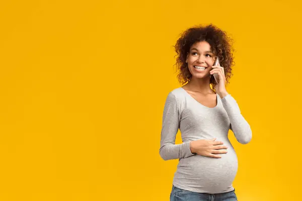 stock image Excited pregnant woman talking on smartphone, having pleasant conversation on pink background, copy space