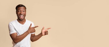 Şuna bak. Heyecanlı Afro-Amerikan adam sarı stüdyo arka plan üzerinde copy space kenara parmaklarını işaret. Panorama