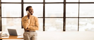 İş kavramı. Afrikalı yönetici, akıllı telefonlardan iş problemlerini uzaktan çözüyor. Boş boşluk