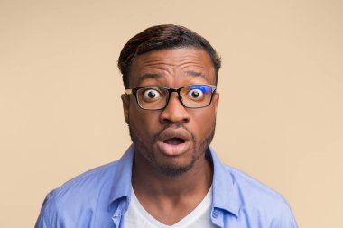 Şaşkınlık. Sarı Stüdyo 'nun arka planında ağzı açık poz veren Afrikalı Amerikalı adam kameraya bakıyor..