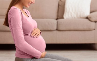 Geçen Hamilelik Ayı. Karnına dokunan hamile bir kadının yan görüntüsü. Boşluğu kopyala