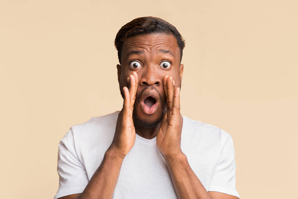 - Привет. Удивлённый афро-человек кричит, держа руки у рта, позируя в студии на жёлтом фоне.
.