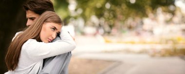 İlişkiye takılıp kaldım. Mutsuz Kız Sevmediği Sevgilisine Kucaklıyor Dışarıda Parkta Duruyor. Metin için Boş Alan