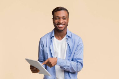 Harika bir uygulama. Gülümseyen Afrikalı Amerikalı Adam Sarı Arkaplanda Dijital Tablet Kullanıyor. Stüdyo Çekimi