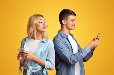Hile ve aldatma kavramı. Meraklı sarışın kız omuz üzerinden erkek arkadaşları cep telefonu içine gözetleme. Kopyalama alanı