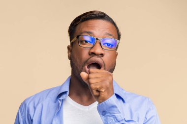 Can sıkıntısı. Uykucu Afro Adam Esneyen Ağzı Sarılar Arkaplanda Eli Ayakta Duruyor. Stüdyo Çekimi