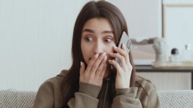 İnanılmaz bir haber. Şaşırmış kız telefonla hoş bilgiler alıyor, evdeki karantinada oturuyor.