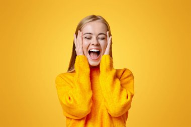 Bu inanılmaz. Heyecandan yüzüne dokunan şaşkın duygusal kız, satış fiyatlarını görünce şok oluyor, fotokopi alanı olan turuncu arka plan.