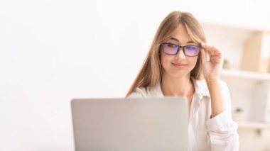 Bilgisayar Gözlüğü. Modern Ofiste Çalışan Kadın Dizüstü bilgisayar kullanıyor. Seçici Odaklanma
