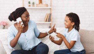 Kharkiv, Ukrayna - 18 Ekim 2019: Afro Kadın iPhone 11 'de Konuşuyor, Kız iPhone 11 Pro Max ile Oynuyor