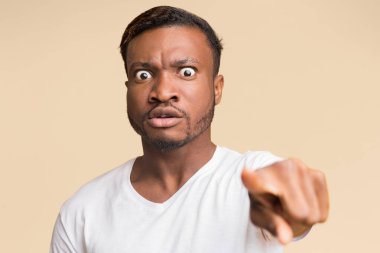 Öfke. Sarı Stüdyo Arkaplan 'ın üzerinde duran kamerayı işaret eden deli Afrikalı Amerikalı adam. Seçici Odaklanma