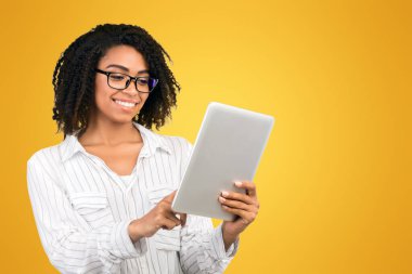 Program kontrol ediliyor. Gülümseyen siyah kadın kişisel tablet üzerindeki randevuyu beyaz arkaplan üzerinden kontrol ediyor, kopyala alanı