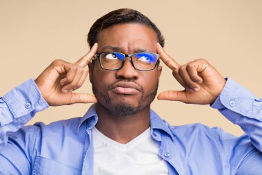 Yaratıcı Düşünce. Düşünceli siyah adam, alnını işaret eden bir fikir üzerinde yoğunlaşıyor. Sarı arka planda duruyor.