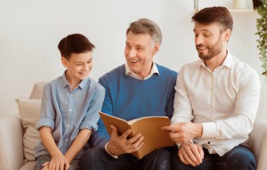 Küçük çocuk, babası ve dedesi evde oturmuş kitap okuyorlar. Baba ve büyükbabayla hafta sonu. Seçici Odaklanma