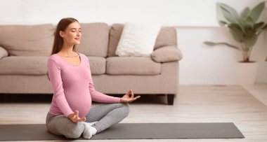 Hamile kalmak için en iyi yaş. Sakin, hamile bir kadın minderde yoga yapıyor. Boş alan