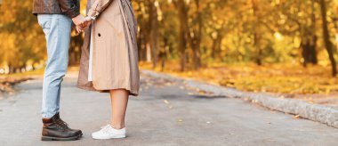 Aşıklar birbirlerine karşı durur ve sonbaharda halk parkında el ele tutuşurlar.