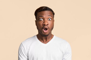 Şaşkınlık. Şok olmuş Afro Adam, sürpriz bir şekilde sarı arka planda duruyor. Stüdyo Çekimi