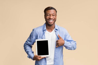 Güzel uygulama. Boş Tablet Ekranı Gösteren Mutlu Afrikalı Amerikalı Adam Sarı Arkaplanda Başparmak Kalkıyor. Stüdyo Çekimi, Model