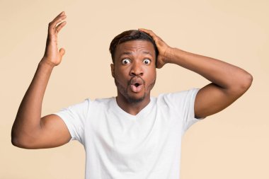 Tüh. Kafasını tutup, sarı arka planda duran kameraya bakarak hareket eden afro-amerikalı adam şok oldu..