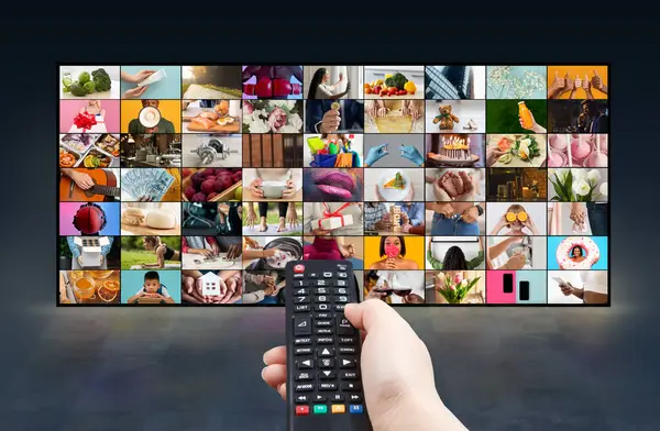 Bir insan eli büyük bir televizyon ekranının önünde siyah bir uzaktan kumanda tutar. Televizyon ekranında çeşitli sahne ve etkinlikleri gösteren çok sayıda renkli resim yer alıyor.