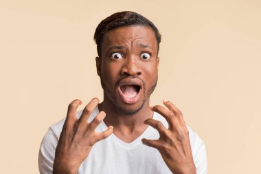Korkudan. Ürkmüş Afro Adam Korkuyla Çığlık atıyor Yüze yakın el ele tutuşup Sarı Stüdyo Arkaplanı 'na bakıyor