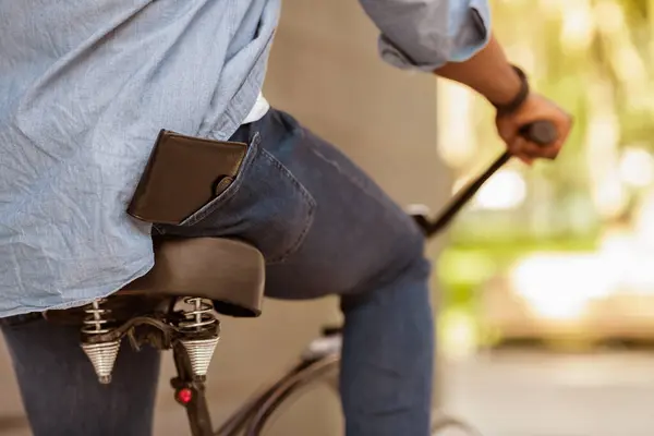 stock image Leather Wallet Falling Down From Pocket Of Unrecognizable African American Man On Bike, Cropped Image, Closeup