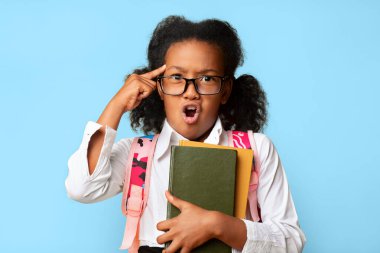 Sarı arka plandaki bir şeyi onaylamayan kameraya bakan Afrikalı liseli kız. Stüdyo Çekimi