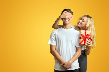 - Sürpriz. Sevgi dolu kız, erkek arkadaşına romantik bir hediye hazırladı. Stüdyoda sarı arka planda dururken gözlerini kapadı.