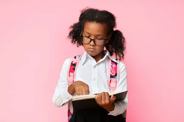 stock image Dyslexia Concept. African Schoolgirl Learning To Read Holding Book Standing In Studio On Over Yellow Background.