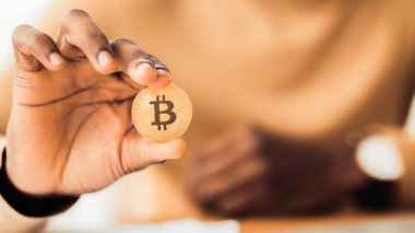 Dijital Para Birimi. Afrikalı işadamı altın Bitcoin 'i tutuyor, yakın plan. Panorama, seçici odaklanma