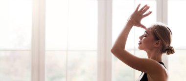 Evde yoga yapan kızın portresi, çakraları açmak, namaste jestinde el ele tutuşmak, yan görüş.