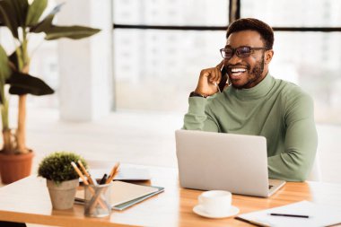 Telefon danışmanlığı. Milenyum siyahi adam müşterisiyle cep telefonuyla konuşuyor ve gülümsüyor, boşluğu kopyalıyor