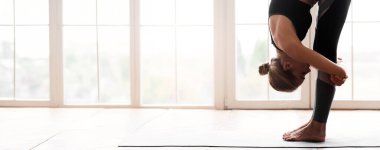 Sportif kadın öne eğilip poz veriyor, evde egzersiz yapıyor, yakın çekim yapıyor, boşluğu kopyalıyor.