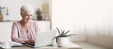 Olgun çekici iş kadını işini seviyor, evde dizüstü bilgisayarla çalışıyor, boş yer var.