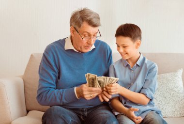 Torunuyla birlikte para sayan kıdemli bir adam ona nasıl para kazanacağını ve evdeki koltukta nasıl yatırım yapacağını anlatıyor.