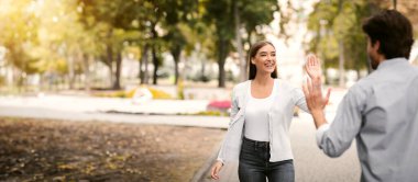 Merhaba. Merhaba. El sallayan kız, parkta gezen arkadaşla buluşuyor. Seçici Odaklanma
