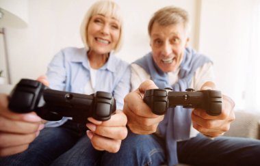 Modern büyükanne ve büyükbaba. Üst düzey çift video oyunları oynuyor, evde eğleniyor