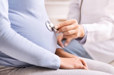 Tanımlanamayan Doktor Tutucu Stetoskop Hamile Kadınların Göbeğinde Çocuğun Kalp atışlarını Evde Dinliyor. Hamilelik danışmanlığı. Kırpılmış