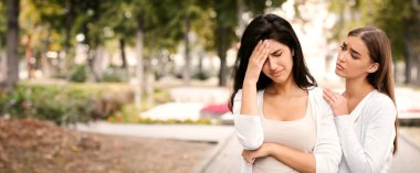 Arkadaşlık ve destek. Şefkatli Kız Çaresizce Rahatlatan Kadın Arkadaş Dışarıda Park 'ta Duruyor.