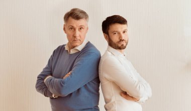 İlişki sorunları. Ciddi Yetişkin Oğlu ve Kıdemli Babası Sırt sırta verip Beyaz Duvara Karşı Karşıya Geçiyor