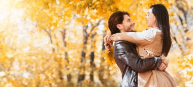 Neşeli adam mutlu kız arkadaşını kaldırıyor, Autumn Forest 'ta birlikte vakit geçiriyor, fotokopi odasıyla panorama yapıyor.