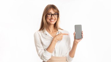 Mobil Uygulama. Beyaz Stüdyo Arkaplan 'da duran Smartphone Boş Ekranı' nı işaret eden gülümseyen kadın. İzole edilmiş, Mockup