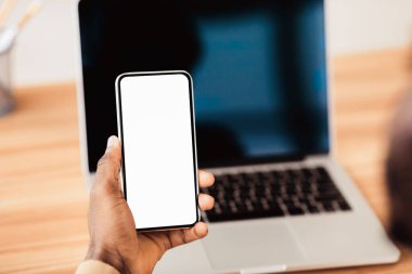 Modern Teknolojiler. Tanımlanamayan siyah iş adamı elinde boş ekranlı akıllı telefon tutuyor.