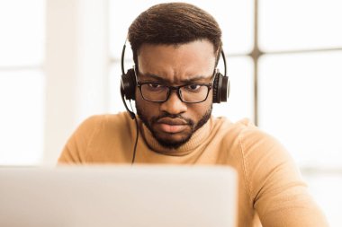 Yardım hattı konsepti. Odaklanmış Afrikalı arama merkezi ajanı. Laptopa bakan müşteri danışmanı. Boş boşluk