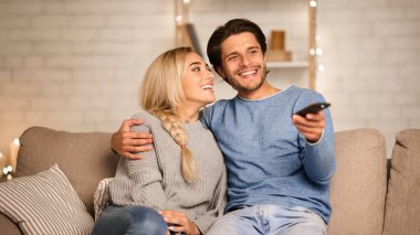 Sevimli bir çift televizyon seyrediyor, evde rahat bir atmosferin tadını çıkarıyor, boş bir alan.