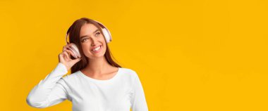 Hamilelik Müziği. Gülümseyen, kulaklıklı kız pembe arka planda şarkı dinliyor. Stüdyo Çekimi